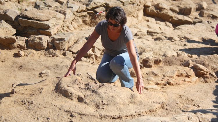 L'arqueòloga Anna Maria Puig assenyala el diàmetre de la campana descoberta © ACN