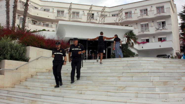 Els dos agents sortint de l'Hotel Marina Sand després d'haver certificat el cessament de l'activitat © ACN