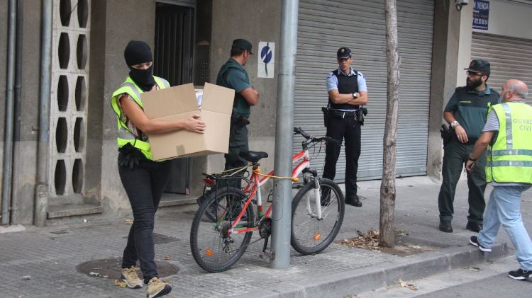 Agents de la Guàrdia Civil s'emporten caixes amb material intervingut durant un escorcoll a Salt © ACN