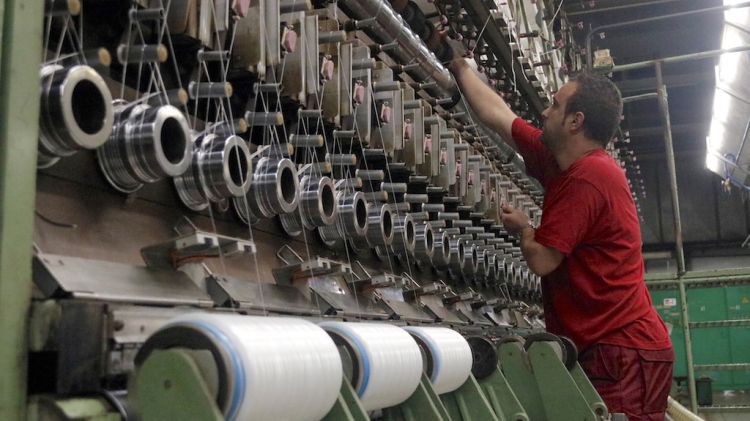 Un treballador comprovant una de les màquines de la tèxtil Nylstar (arxiu)