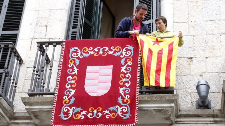 Els regidors de la CUP Laia Pèlach i Lluc Salellas penjant l'estelada a un balcó de l'Ajuntament © ACN