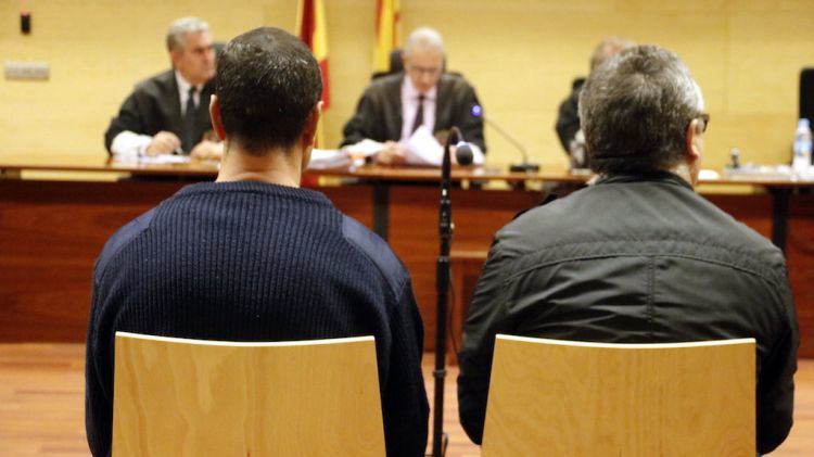 D'esquenes i a l'esquerra, l'acusat de violar una indigent a Girona durant el judici (arxiu) © ACN