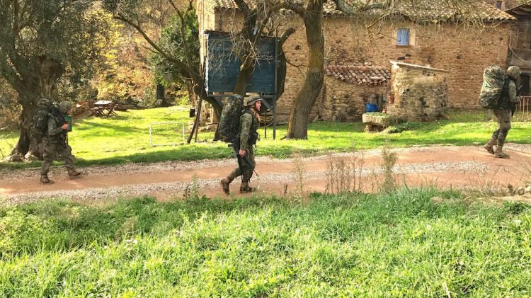 Militars passant, armats, pel costat d'una casa a Canet d'Adri © ACN