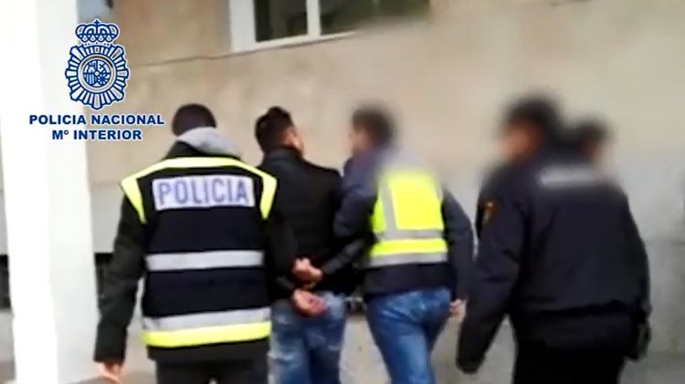 Agents de la policia espanyola condueixen el detingut, emmanillat, a les dependències policials