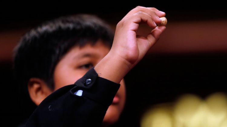 Un nen de San Ildefonso mostra un quart premi © ACN