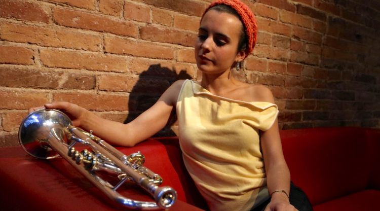 Andrea Motis observa el seu instrument, asseguda en un sofà en un hotel de Barcelona. ACN