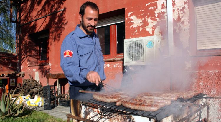 Un dels efectius del cos de Bombers de Figueres preparant la botifarrada de protesta. ACN