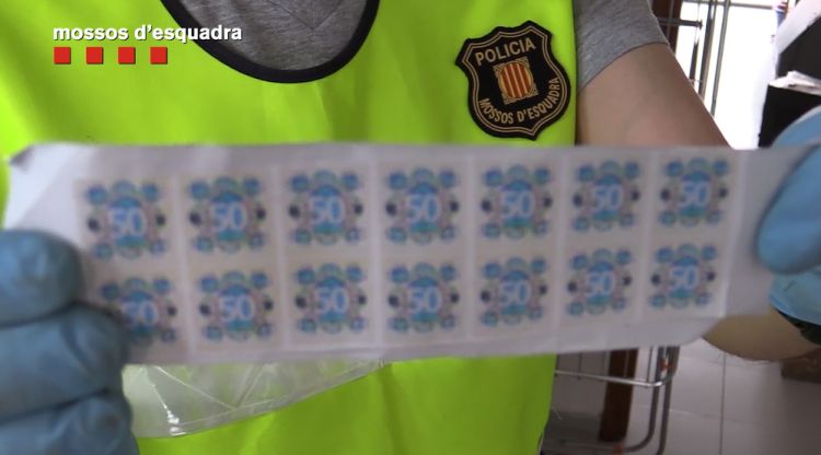 Un mosso mostra part del material intervingut per falsificar els bitllets de 50 euros