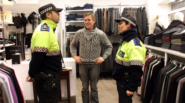 Un agent de la Policia Municipal i una agent cívic donen consells de seguretat a una botiga de roba a Girona (arxiu). ACN