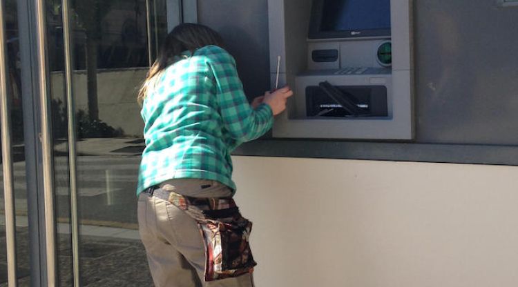 Una operària reparant el caixer el Banc Popular de Llagostera. ACN