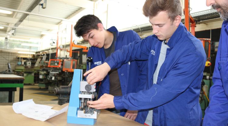 Alumnes de l'institut La Garrotxa d'Olot amb el prototip de premsa per fer ceràmica. ACN