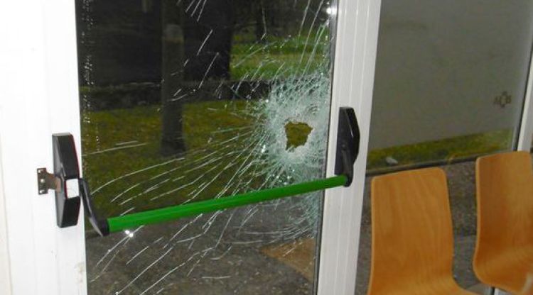 El vidre de la porta trencat a cops de martell