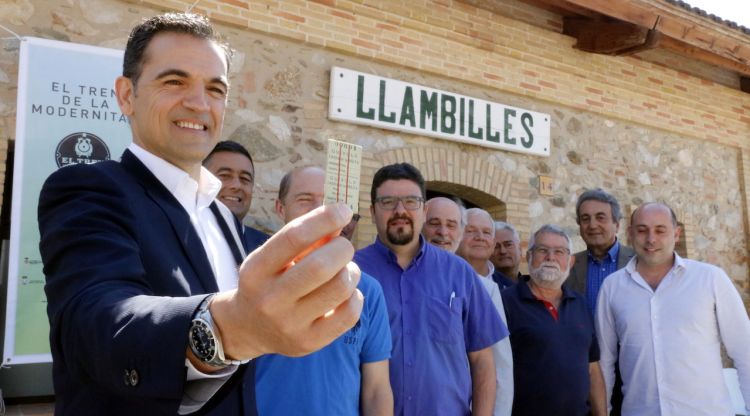 L'alcalde de Sant Feliu de Guíxols, Carles Motas, en primer terme ensenyant un dels bitllets del carrilet