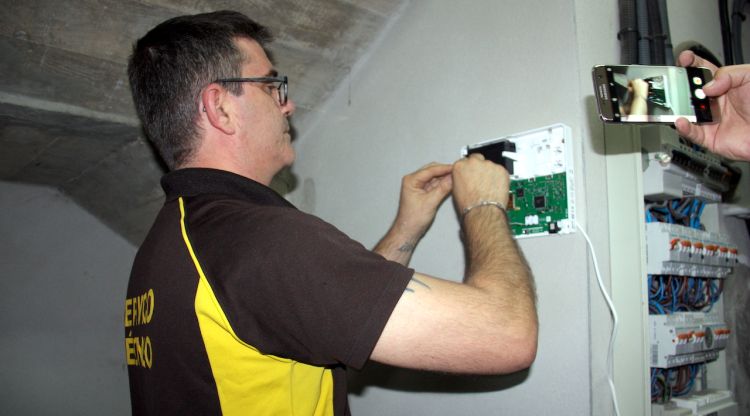 Un tècnic de la central d'alarmes instal·lant un dels dispositius per controlar l'accés a la zona de comptadors. ACN