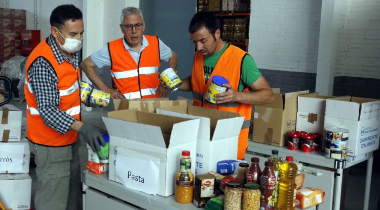 Voluntaris distribuint menjar en caixes a la seu del Banc dels Aliments de Girona. ACN