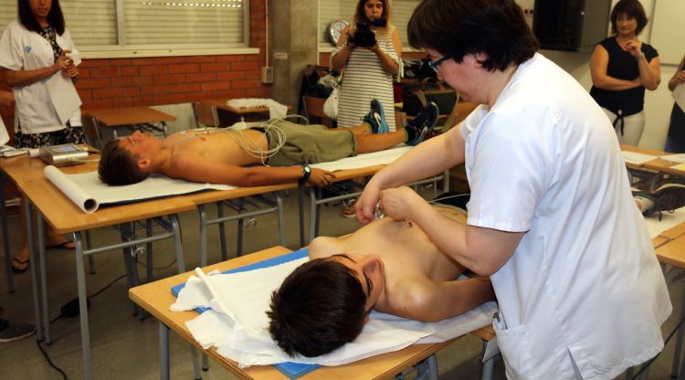 Una infermera fent un electrocardiograma a un jove de l'institut Pere Alsius de Banyoles. ACN