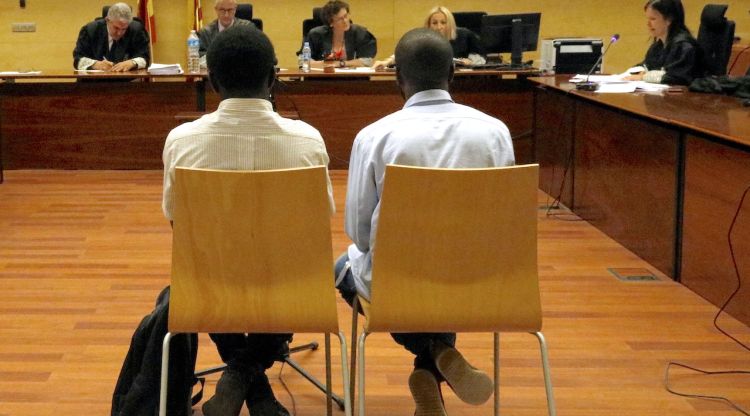 D'esquenes i al costat de l'intèrpret, l'acusat d'agredir sexualment una nena de 10 anys a Arbúcies. ACN