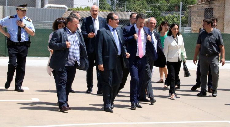 El conseller d'Interior, Jordi Jané, camina per l'exterior de la nova comissaria acompanyat de l'alcalde de Banyoles, Miquel Noguer. ACN