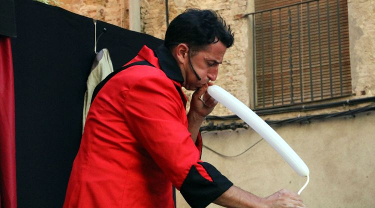 Un artista inflant un globus en un dels espectacles d'avui. ACN