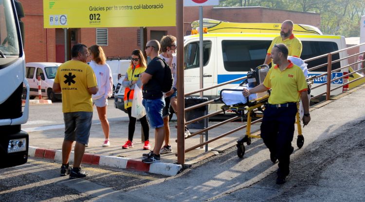 Dos tècnics d'ambulàncies amb una camilla passen per davant del piquet que hi havia a l'hospital Josep Trueta. ACN