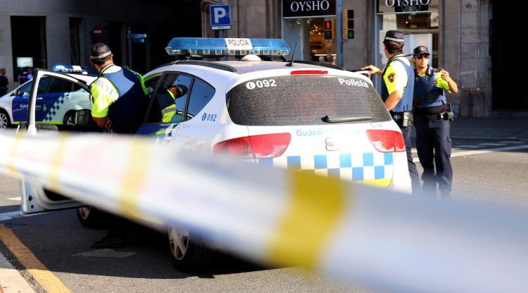 Un vehicle amb agents de la Guàrdia Urbana davant del cordó policial del carrer Pelai de Barcelona. ACN