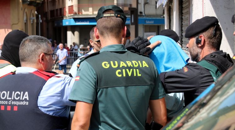 Els Mossos d'Esquadra i la Guàrdia Civil s'emporten el segon detingut a Ripoll que porta una tovallola blava al cap. ACN