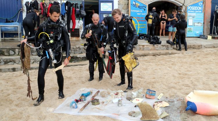 Tres submarinistes deixant les deixalles que han recollit al fons del mar. ACN