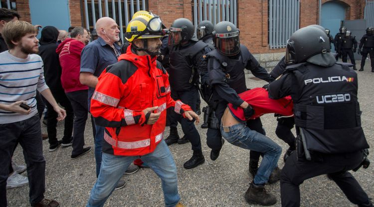 Policia espanyola agredint a uns Bombers durant la jornada de l'1-O a Girona (arxiu). ACN