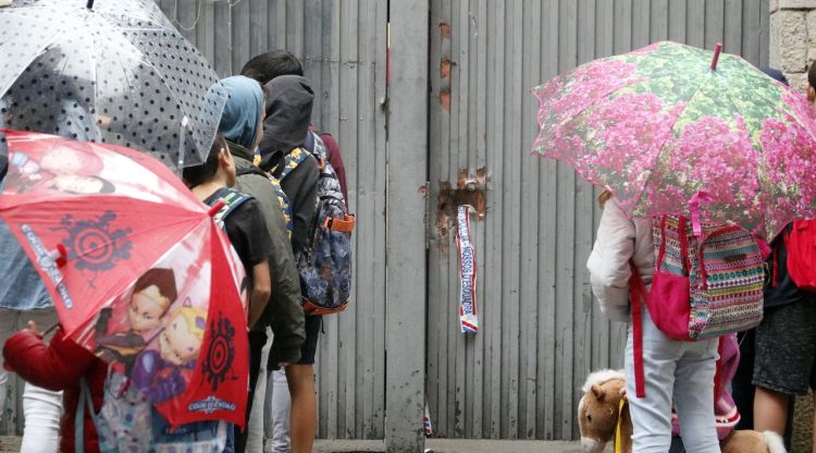 Alumnes del col·legi Verd esperant per entrar per la porta destrossada per la policia espanyola. ACN