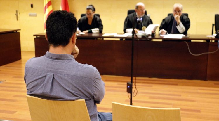 D'esquenes, l'agent dels Mossos d'Esquadra de Sant Feliu de Guíxols durant el judici a l'Audiencia de Girona. ACN