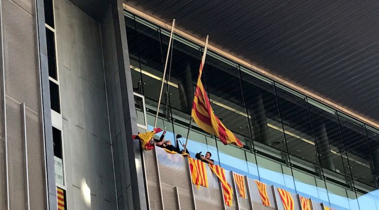 Moment en què s'ha despenjat la bandera espanyola de la façana de la seu de la Generalitat
