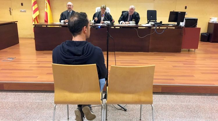 D'esquenes, l'acusat d'estafar dues parelles durant el judici a l'Audiència de Girona. ACN
