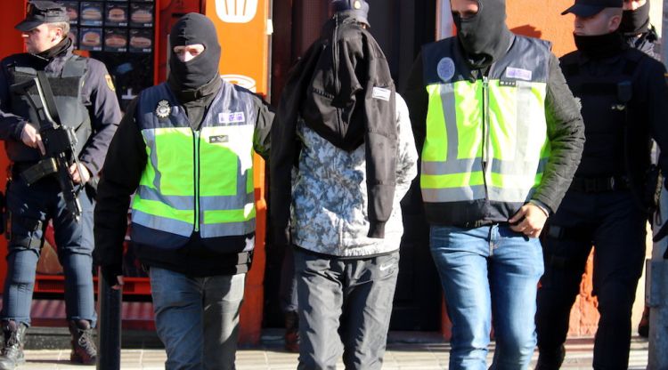 Agents de la policia espanyola s'enduen un dels dos germans detinguts a Figueres. ACN