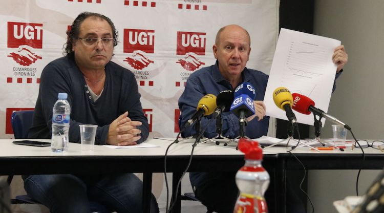 Josep Bonet (esquerra), tècnic en riscos laborals i el secretari general d'UGT a Girona, Xavier Casas, mostrant una gràfica de sinistralitat. ACN