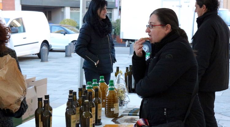 Una dona provant l'Oli de l'Empordà sucat amb pa aquest matí a Girona. ACN