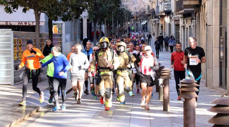 Els corredors amb dos Bombers equipats a la cursa d'avui a Girona. ACN