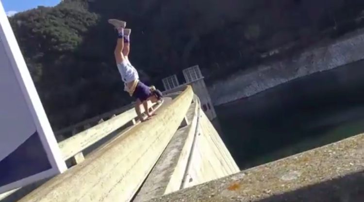 Un jove realitzant acrobàcies davant l'abisme. powerstreetunity_official