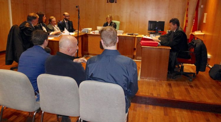 D'esquenes i amb el traductor al mig, els dos únics acusats que s'han presentat al judici. ACN