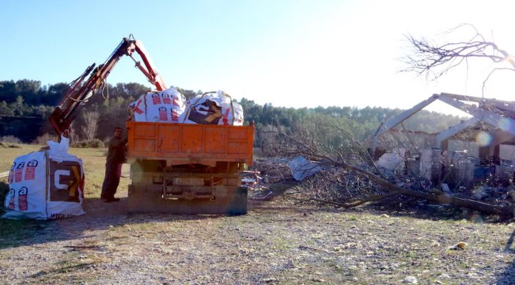 Un camió amb restes d'uralita a tocar d'una de les masies afectades pel pas del tornado a Terrades. ACN