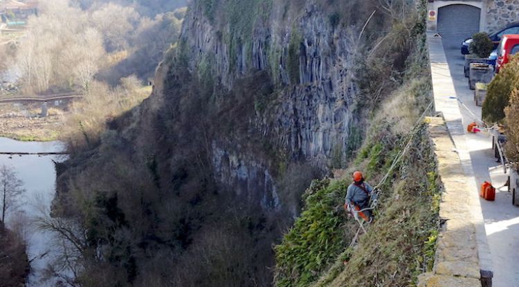 Un operari fent la neteja de la cinglera de Castellfollit de la Roca. ACN