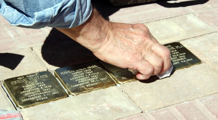 Detall del moment en què l'escultor Gunter Demnig col·loca les plaques Stolpersteine. ACN