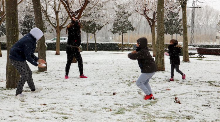 Un grup de nens jugant amb la neu en un parc de Llagostera. ACN