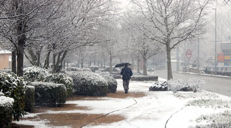 Un veí de Maçanet de la Selva camina sota la neu. ACN