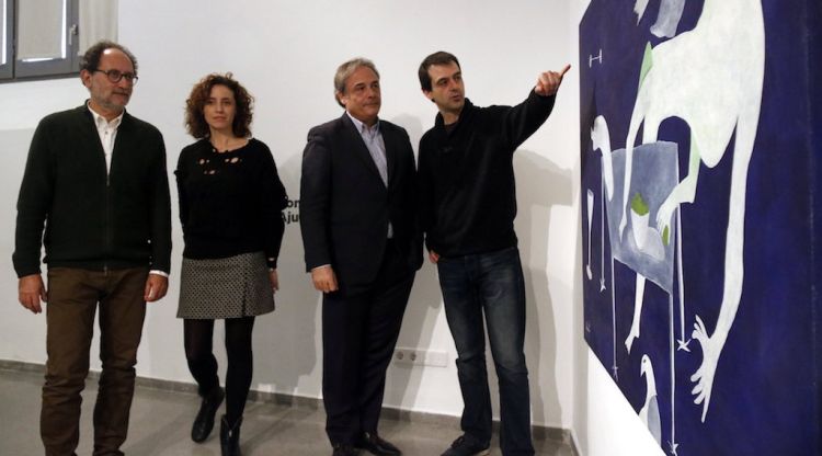 El regidor de Cultura, Carles Ribas, amb els responsables del centre cultural La Mercè, mirant una obra exposada. ACN