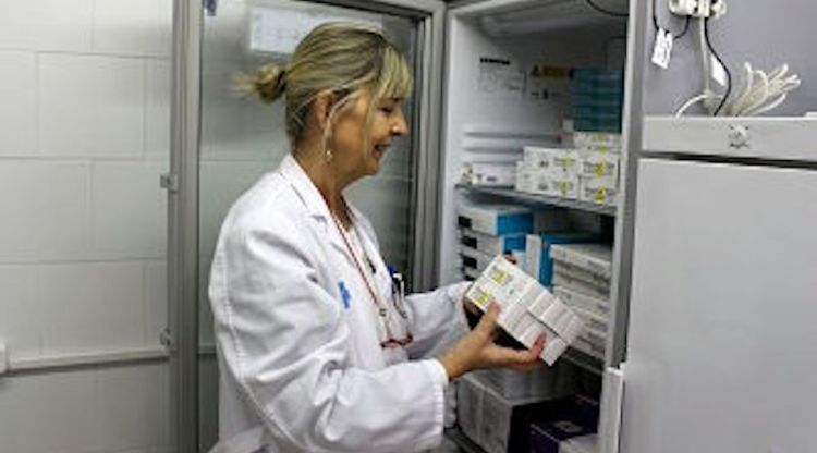 Una treballadora d'un centre mèdic de Girona retirant dosis d'una de les neveres que guarden les vacunes