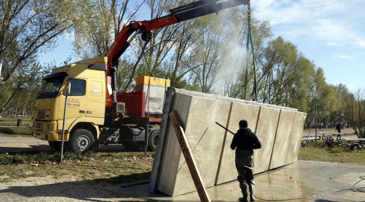 Un operari desinfecta una de les peces de l'estructura flotant. ACN
