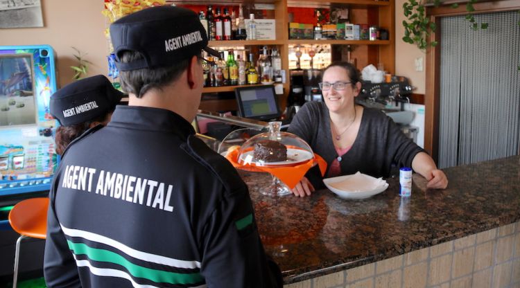 Els agents ambientals de Girona visitant un comerç de la ciutat. ACN