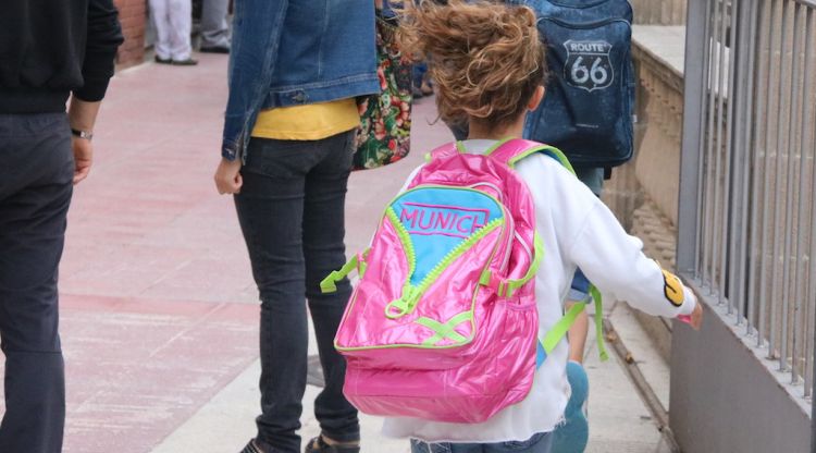 Una nena corrent amb la maleta a l'esquena tornant cap a l'escola a Ripoll (arxiu). ACN