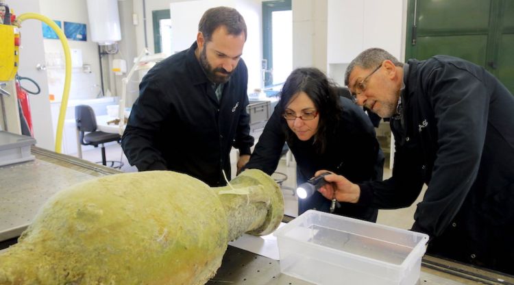 Els tres arqueòlegs examinant l'interior d'una de les àmfores de fa 2.000 anys que s'han extret del vaixell romà de les Formigues. ACN