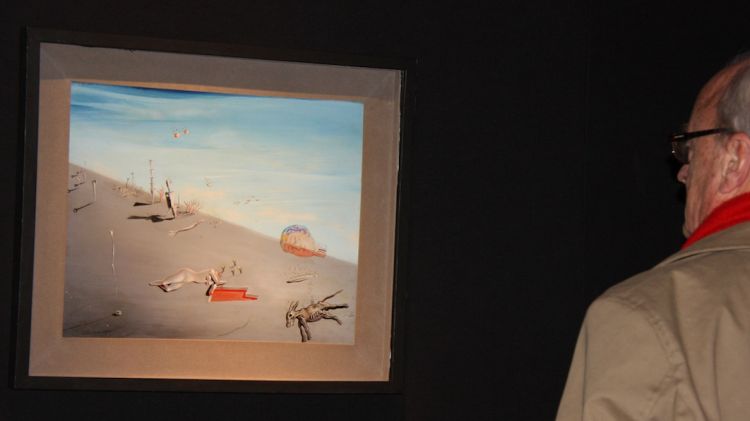 Un home observant una obra de Salvador Dalí adquirida per la fundació